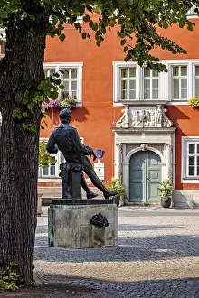 Johann Sebastian Bach Memorial Drucke: A statue in a square in front of a red