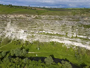Drucke von Steile Klippen mit dichtem Grün und einem Flusslauf am Fuß in einer grünen Umgebung, Luftaufnahme, Höhlenwohnungen, Răut-Fluss, Raut, Alt-Orhei, Orheiul Vechi, archäologische Stätte Moldawien Drucke: Steile Felswände mit dichtem Grün und einem Flusslauf am Fuß in einer grünen Umgebung.