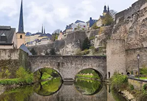 Drucke von Steinbrücke, die im Wasser spiegelt, und die Ruinen eines ehemaligen berühmten Schlosses, das die Kultur und Geschichte Luxemburgs in der Zeit des Mittelalters darstellt Schloss Drucke: Steinbrücke im Wasser spiegelt.