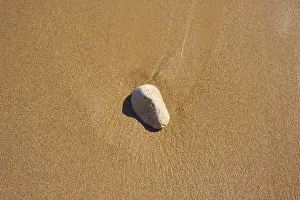 Southern Europe Coast Drucke: Stone lying in the sand on a beach