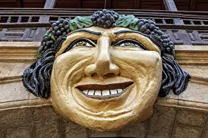 Potosi Drucke: Steinmaske mit lächelndem Gesicht auf einer architektonischen Struktur.