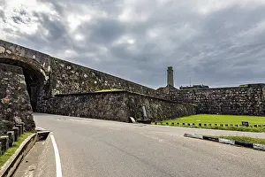 Stone Wall Drucke: Stone wall along a road under a dramatic cloudy sky