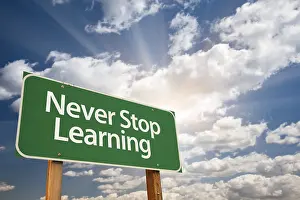 Green Road Safety Sign Drucke: Never stop learning green road sign with dramatic clouds and sky