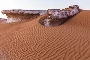 Arabian Peninsula Cliffs Drucke: Striking cliffs surrounded by windswept sand structures