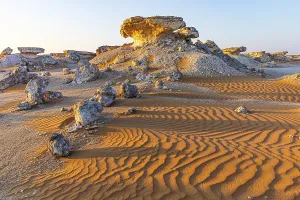 Deserted Omani Landscapes Drucke: Striking cliffs surrounded by windswept sand structures