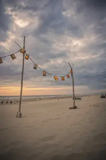 Benelux Holiday Region Drucke: String of lights on wooden post on beach at sunset