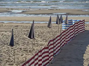 Deserted Sandy Beaches Europe Drucke: Striped windbreaks on the sandy beach with erected