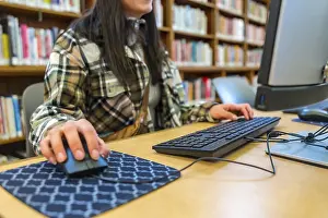 Online Education Drucke: Student hands typing on keyboard and operating mouse at a desktop computer