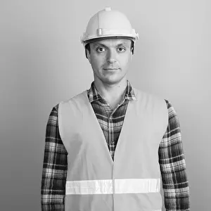 Construction Worker Drucke: Studio shot of man construction worker against gray background