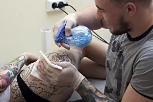Professional Tattooist Drucke: Studio shot of smiling tattoo master at work