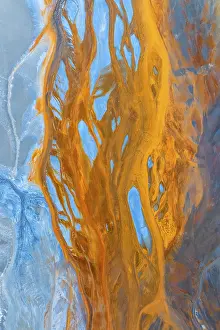 Drucke von Dies beeindruckende Luftaufnahme erfasst ein farbenfrohes Landschaftsbild, das eine feine Mischung aus blauen und goldenen Nuancen zeigt, die einer flüssigen Kunst ähneln Kunstwerke Des Surrealismus Drucke: Dies beeindruckende Luftaufnahme zeigt eine multikolorierte Landschaft.