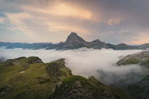 Morning Mountain Scenery Drucke: A stunning view of a mountain peak emerging above thick clouds