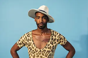One Person Studio Photo Drucke: Stylish guy posing in studio against blue background looking at camera