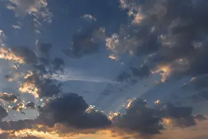 Cloudy Atmosphere Europe Drucke: Sun behind the clouds in the evening sky