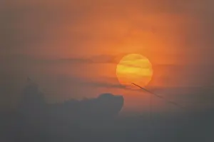 France Travel Photography Drucke: Sun disk through the clouds at sunset above the horizon