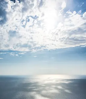 Sunbeams Over Water Drucke: Sunlight shining through clouds over the sea