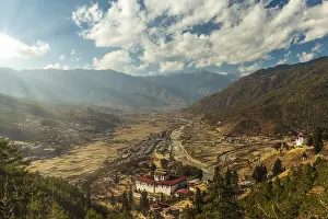 Cloudy Sunset Drucke: Sunrays through the clouds as the sun is setting over Paro