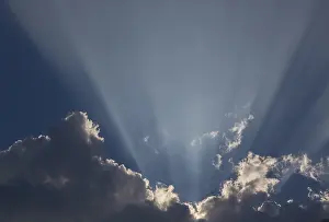 Cumulus Humilis Cloud Drucke: Sunrays behind a dark cumulus cloud, Germany