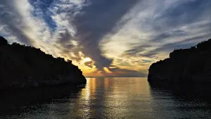 Greek Peninsula Landscape Drucke: Sunrise with a view through a bay between cliffs and clouds