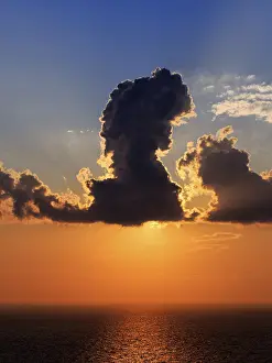 Santorini Sunset Drucke: Sunset behind clouds at the sea