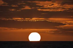 Evening Sun Africa Drucke: Sunset with clouds, sun sinking into the sea