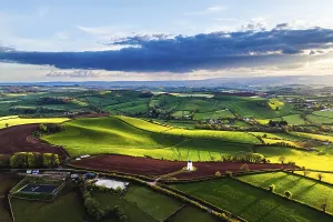 British Countryside Landscape Drucke: Sunset of Devon Windmill over Fields and Farms from a drone