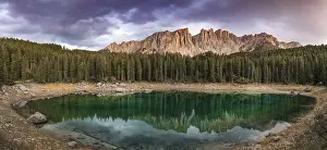Evening Atmosphere In The Alps Drucke: Sunset, dramatic clouds, Latemar group reflected in the Karersee