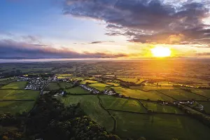 Agricultural Landscapes From Above Drucke: Sunset over Fields and Farms from a drone