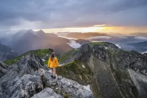 Bavarian Mountain Landscapes Drucke: Sunset, hiker looking at mountains and peaks under dramatic clouds