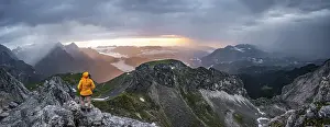 Wetterstein Mountains Drucke: Sunset, hiker looking at mountains and peaks under dramatic clouds