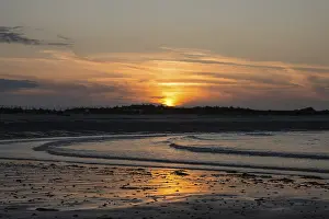 Deserted North Sea Coast Drucke: Sunset on a quiet beach with soft light on the waves