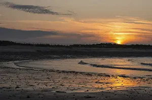 Atmospheric Light Drucke: Sunset on a quiet beach with soft light on the waves