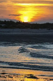 Low Tide Beach Scene Drucke: Sunset on a quiet beach with soft light on the waves