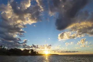 Deserted Beach At Sunset Drucke: Sunset with rays and round cloudscape on blue sky at Cowes