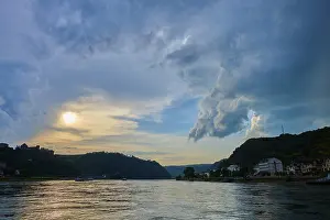 Deserted Riverbank Scene Drucke: Sunset over a river with dramatic clouds and hills on the horizon