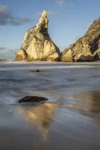 Sandy Ocean Beach Scenery Drucke: Sunset on sandy beach with rocks