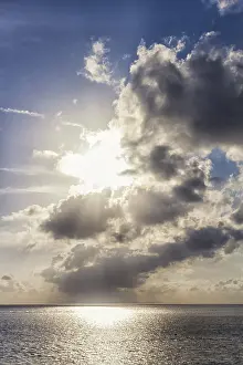 Deserted Coastline Scene Drucke: Sunset over the sea with the sun rays through the clouds