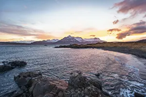 Coastal Area With No People Present Drucke: Sunset over snow-capped mountains