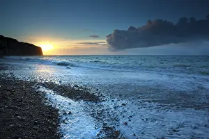 Rocky Shoreline Europe Drucke: Sunset over stone beach in Atlantic ocean