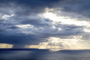 Sunset In Southern Europe Drucke: Sunset, sun rays over sea, dark rain cloud