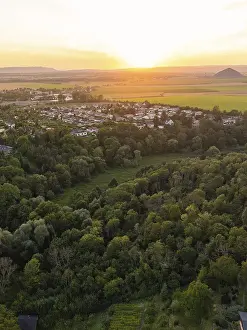 Deserted Village At Sunset Drucke: Sunset over a village with surrounding fields and forest