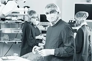 Healthcare Professional Drucke: Surgeon looking at camera with colleagues