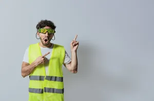 Construction Industry Professional Drucke: Surprised builder worker pointing finger to the right isolated