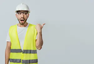 Unterschrift Drucke: Überraschter Ingenieur zeigt zur Seite.