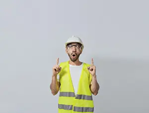 Construction Worker Image Drucke: Surprised young architect pointing up