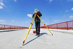 Construction Site Inspection Drucke: Surveyor engineer is measuring bridge under construction