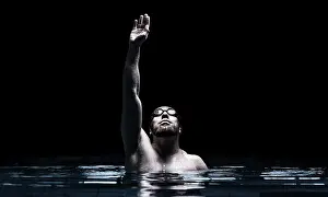 Recreational Water Activity Drucke: Swimmer in the pool raises his hands up