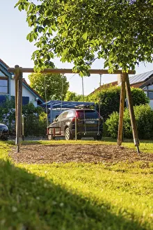 Central Europe Summer Vacation Drucke: A swing in the foreground with a car in the background