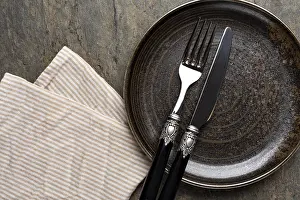 Empty Plate Studio Shot Drucke: Table setting. plate, knife and fork on stone background
