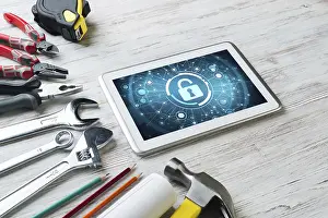 Industrial Tools Around Computer Drucke: Tablet pc with security concept on screen and industrial tools around
